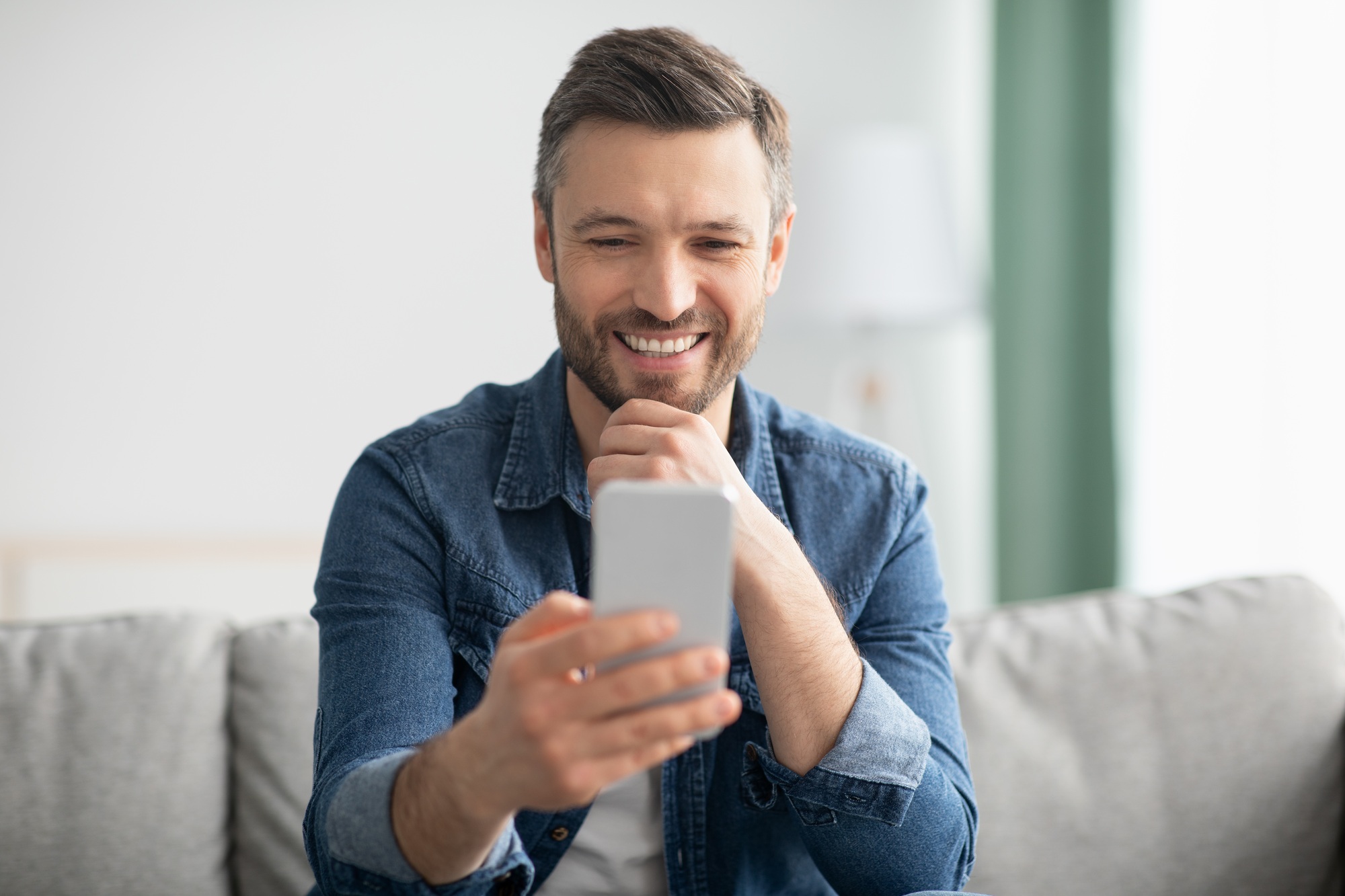Happy middle-aged man enjoying video chat with lover