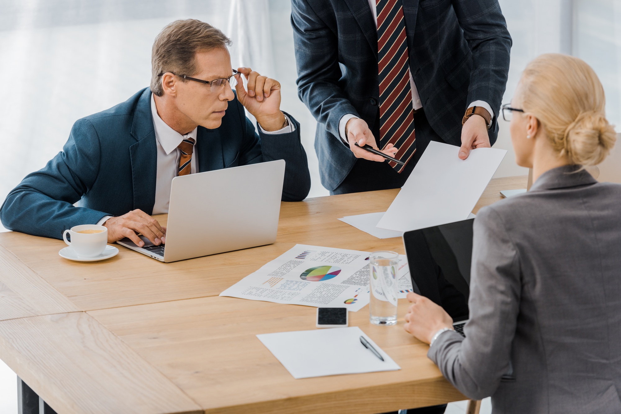 insurance agent showing contract to workers in office